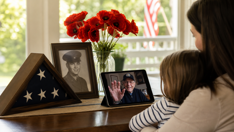 Memorial Day remembrance scene with an American flag, red poppies, a military portrait, and a family video call with an older veteran